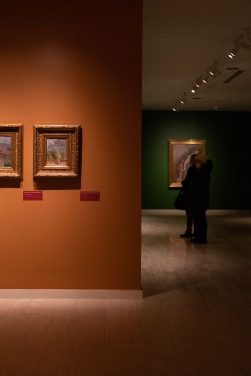 Visitors viewing framed artwork in an art gallery